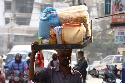 ON DEMAND: A street vendor carries pani-puri and other ingredients on his head as he walks along Jawalakhel on Wednesday.