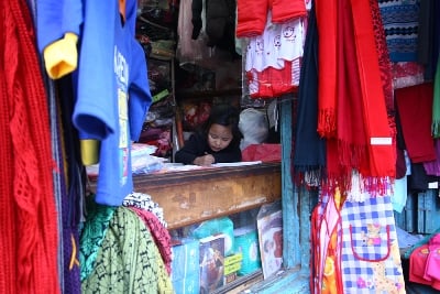 CONCENTRATION: A young girl does her homework in her mother's clothing shop at Lagankhel, Patan, on Friday.