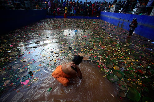 A devotee takes bath in a pond on the premises of Mata Tirtha Temple in Kathmandu on the occasion of Mother's Day on Saturday.