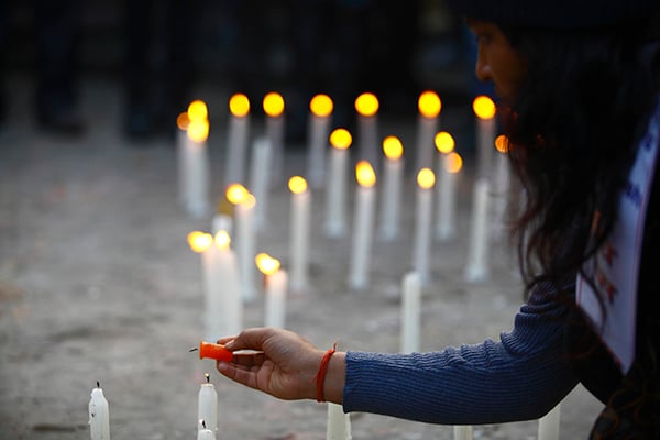 A girl lights a candle at a candlelight vigil organised on the 100th day of the Madhes protests at Maitighar on Saturday.