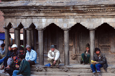 HIRE US: While people rest under the shade of the temple, two porters await potential clients at Patan Darbar Square.