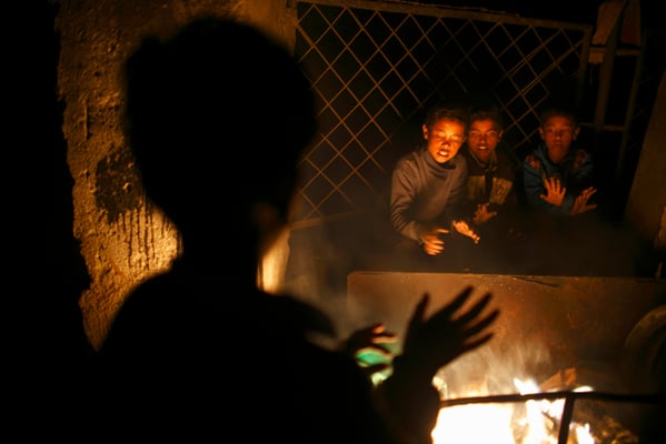 Children warm themselves around a fire near the Bagmati river on Thursday.