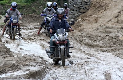 WHAT A MESS: Motorcyclists try to make their way through a muddy dirt road in Sanghu on Sunday morning.