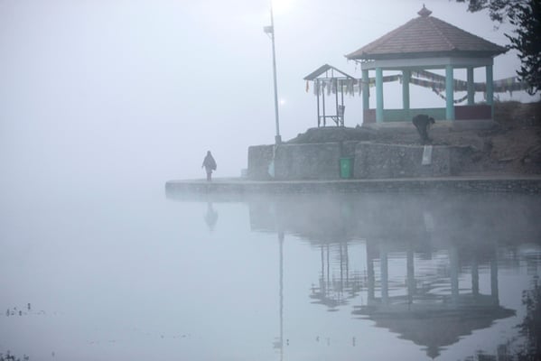 A woman walks past a rest house before sunrise in Taudaha on Friday.