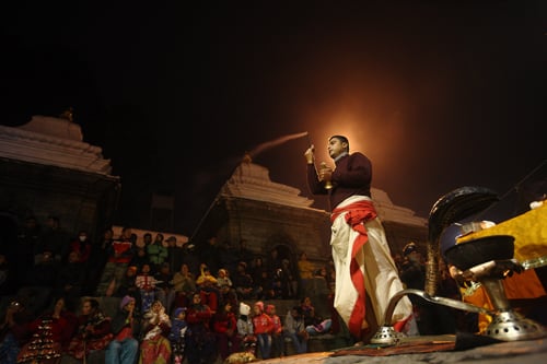 A man performs rituals at Pashupatinath temple on Sunday night.