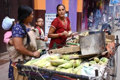BUSINESS’ GOOD: A woman receives money for the roasted maize she’s selling along Mangal Bazaar on Tuesday.