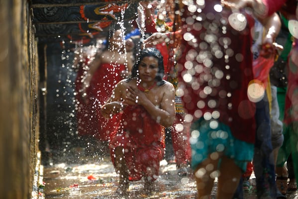 A devotee takes a holy bath at the Balaju Baise Dhara during the Baishak Asnan festival on Tuesday.