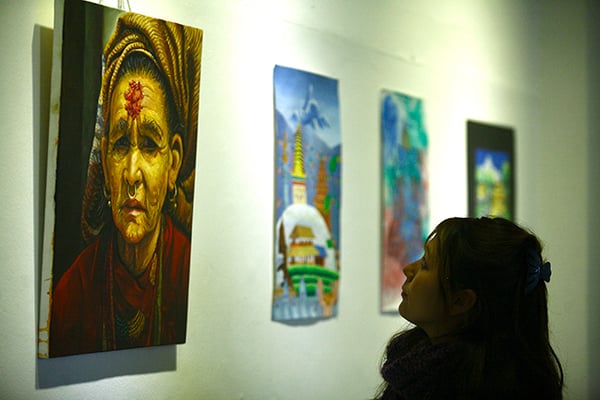 A visitor observes paintings at the inauguration of the Alfresco Open Art Exhibition/ Competition 2015 organised by Alfresco Media and Event Management at Nepal Art council in Babarmahal on Friday.