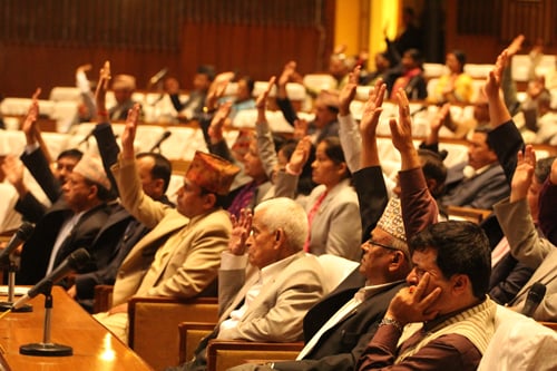 Constituent Assembly (CA) members raise their hands to pass a condolence motion at the demise of former lawmakers Ram Nath Dhakal and Mahendra Yadav on Monday.
