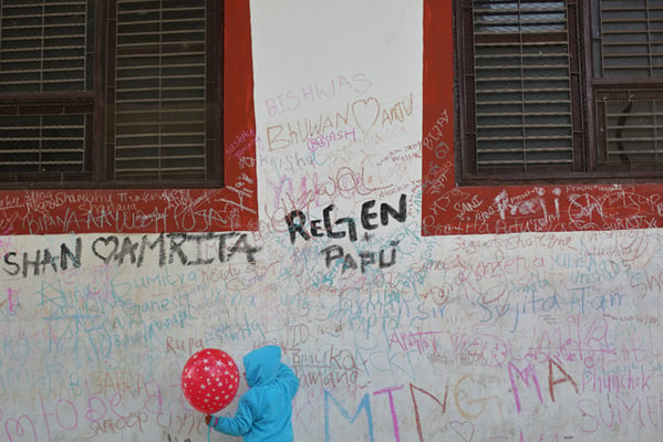 A child writes on the wall near the Saraswati temple in Swayambhunath during Saraswati Puja on Monday.