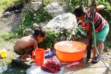 TIME FOR A SIP: Small children take a rest after doing their chores in front of their house in Bandipur on Sunday.