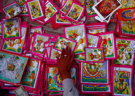 A vendor reaches out for the posters of Goddess Laxmi kept on sale for the Tihar festival in Mangal Bazaar on Wednesday.