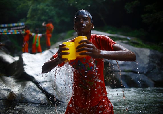 A Hindu devotee collects holy water from the Bagmati River during the 'Bol Bom' pilgrimage in Sudarijaal on Monday.