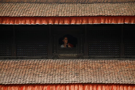 A tourist takes photographs from the window of the Patan Museum on Monday. Heritage sites within Kathmandu Valley were reopened today.