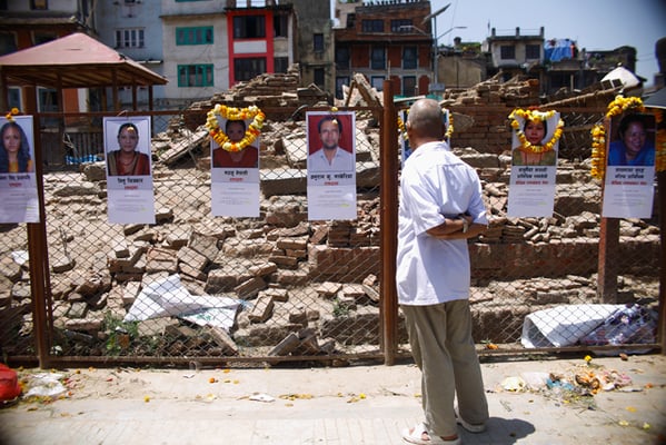 A passersby looks at the photos of the people who lost their lives at Kasthmandap during the 2015 earthquake. The pictures were displayed on Tuesday at Kathmandu Darbar Square to mark the second anniversary of the devastating earthquake.