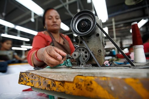 NIMBLE FINGERS: A woman works at a garment factory in Bhaktapur on Monday.