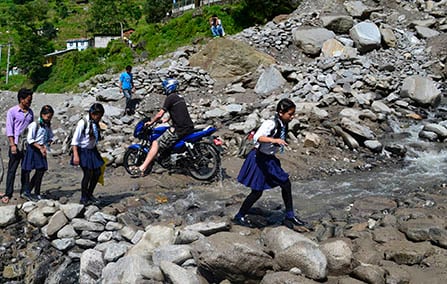 HOP SKIP JUMP: Girls on their way to school near the Friendship bridge in Tatopani.