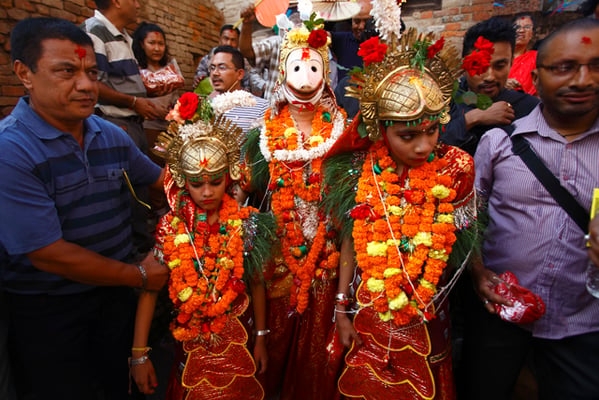Children dressed as Hindu deities Narsingha, Laxmi and Saraswati are taken around Patan during the Narsingha Jatra on Tuesday.
