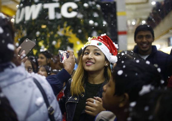 A girl enjoys artificial snow fall during Christmas celebrations at the World Trade Center, Tripureshwor on Monday.