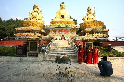 SAY CHEESE: Women pose for a photo in front of statues at the Buddha Park, Swayambhu on Tuesday afternoon.