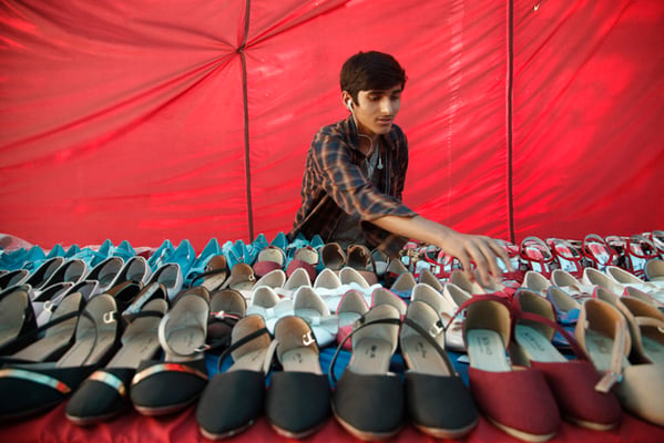 16-year-old Paras Tripathi arranges shoes during a footwear exposition at Bhrikuti Mandap, Kathmandu on Monday.