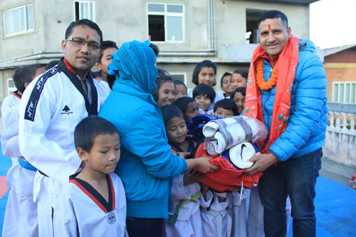 Taekwondo player Deepak Bista donates Taekwondo sparring kit to gang rape victim Puja Bohara on Wednesday.