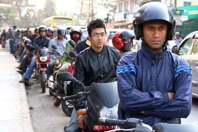 UNHAPPY FACES: Motorcyclists queue impatiently at the side of the road to refuel their vehicles at Jawalakhel on Monday.
