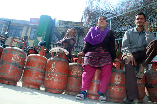 People wait in queue for distribution of gas cylinders at National Trading Limited at Teku on Sunday.