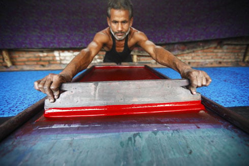 COLOUR TIME: A worker at a garment factory in Naya Bajar adds colour on a garment piece.