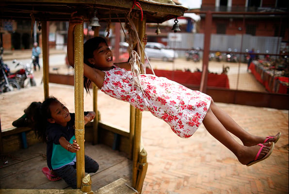 A young girl swings from a palanquin in Bhimsen temple at Patan Darbar Square on Friday.
