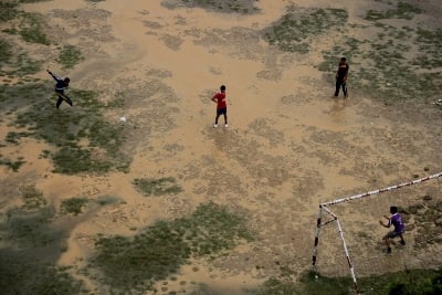 FLOODED PITCH: Students play football despite the heavy rain in Budol, Kavre on Thursday.