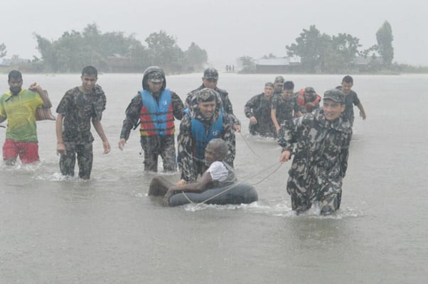 Nepal army personnel rescue an elderly man from a flood-affected area in Jhapa on Sunday. Thousands of people across the country have been forced out of their homes due to floods and landslides caused by torrential rain.