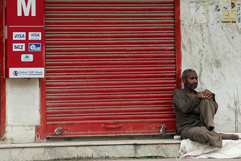 TIRED: A trash collector rests next to a closed shop at Boudha on Tuesday morning.