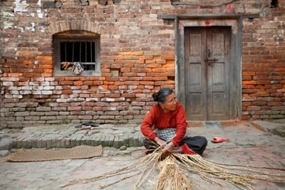 WHERE IT BEGINS: An old woman weaves a straw mat in Lubu, Lalitpur, on Monday.