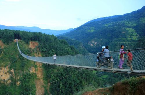 A biker rides over the new suspension bridge in Kushma, Parbat on Thursday. The bridge was opened last week for the general public.