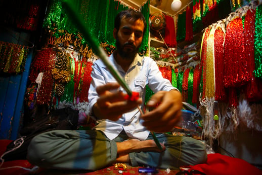 A man weaves a necklace made of traditional beads at Indrachowk on Thursday.