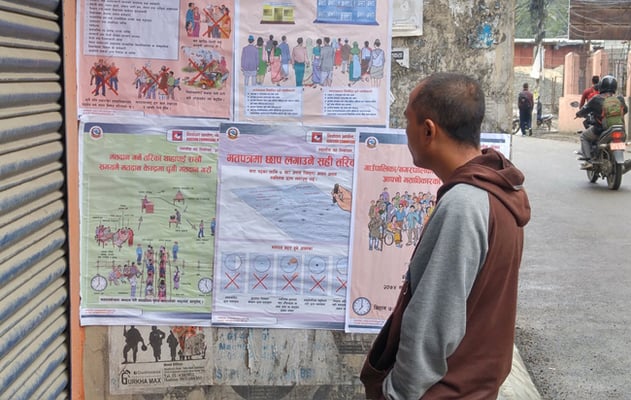 A man looks at voter education posters put up by Election Commission in Lainchaur, Kathmandu on Friday. Nepal is holding local elections on 14 May after a gap of 19 years.