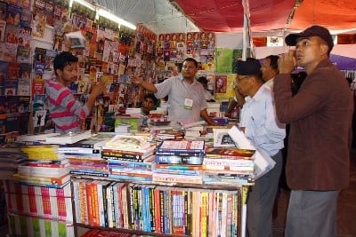 TAKE A BOOK: A stall owner picks out books to recommend to buyers at the Education and Book Fair 2013 held at Bhrikutmandap on Monday.