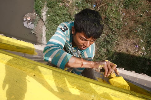 YELLOW YELLOW: Mayaram Chaudhari, 30, of Dang paints the Teku-Sanepa bridge on Monday as part of the Department of Roads' maintenance work.