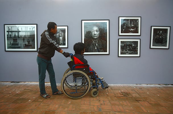 A physically-disabled boy observes a photo exhibition in Patan Darbar Square on Monday. The exhibition is part of Photo Kathmandu, Nepal's first international photo festival.