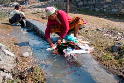 LAUNDRY SERVICE: A woman and a young girl wash their clothes with water from a drain in Chhorepatan, Pokhara on Tuesday.