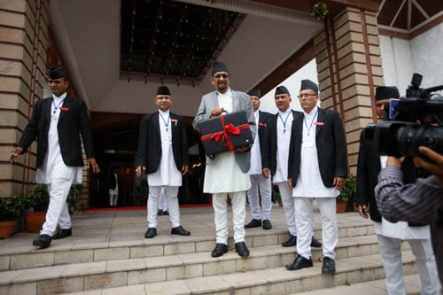 Finance Minister Ram Sharan Mahat poses for photo before entering the Parliament to present the budget for the upcoming fiscal year.