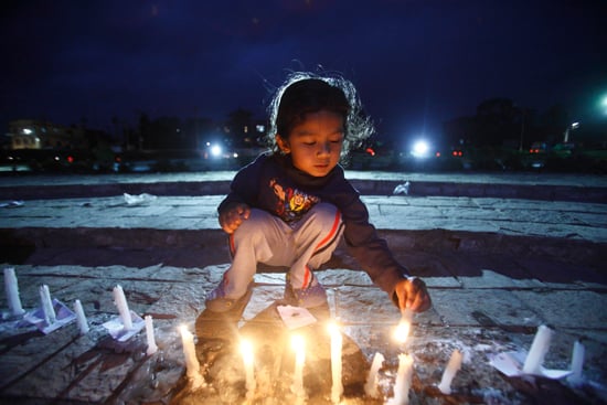 A young girl lights a candle during a candlelit vigil held at Maitighar on Saturday.
