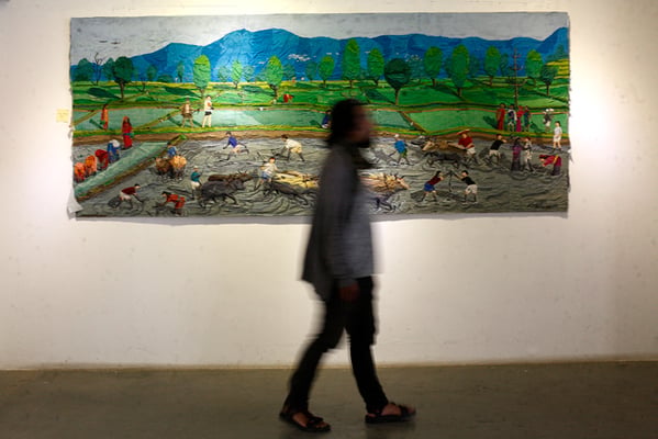 A visitor walks by paintings at an art exhibition titled 'My Creative Approach' organised by Commercial Artist Association of Nepal in Nepal Art Council, Babar Mahal on Wednesday.