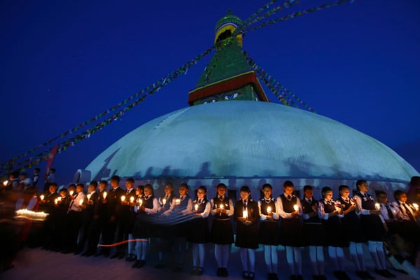 Students gather to attend a candle light vigil on Tuesday at Boudhanath Stupa in Kathmandu to mark the second anniversary of the devastating 2015 earthquake.