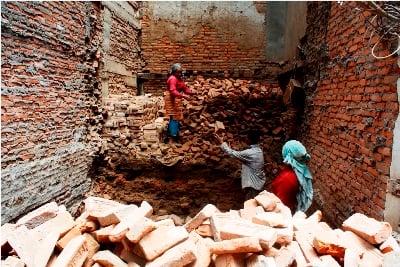 BRICK HOLE: Workers remove bricks from a building construction in Mangalbazar on Thursday.