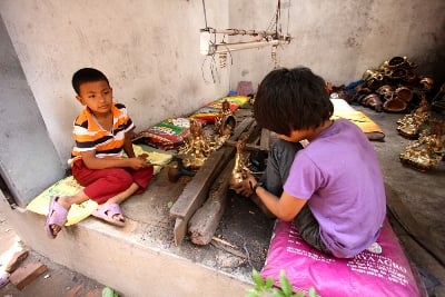 LEARNING ART: Boys work on Buddhist figurines in an empty shop in Patan on Sunday afternoon.