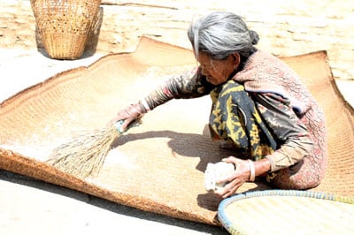 LET THE SUNSHINE IN: An elderly woman dries maize in the sun in Ghurjung on the way to Annapurna Base Camp.