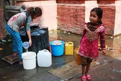 FETCHING WATER: Small girls fill buckets with water for their families in Dhunge dhara at Patan on Thursday.