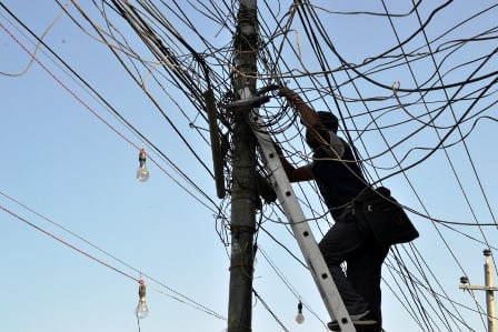 BLURRED LINES: A mechanic fixes electricity wires at Gaushala Chok on Monday for the occasion of Shivarati.